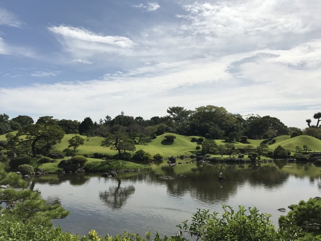 Japanischer Hügelgarten mit Teich im Vordergrund