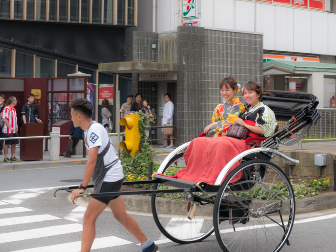 Ein Rikscha-Fahrer mit Gästen in Asakusa
