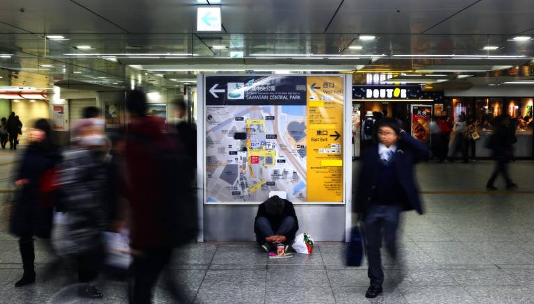 Unbekannter Obdachloser sitzt im Bahnhof Osaka in Osaka, Japan.