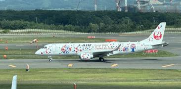 Ein Flugzeug der Japan Airlines mit dem Expo-Maskottchen Myaku-Myaku.