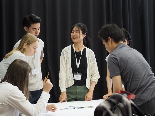 Teilnehmer:*innen einer Arbeitsgruppe erstellen eine Präsentation während des Deutsch-Japanischen Youth Summit 2023.